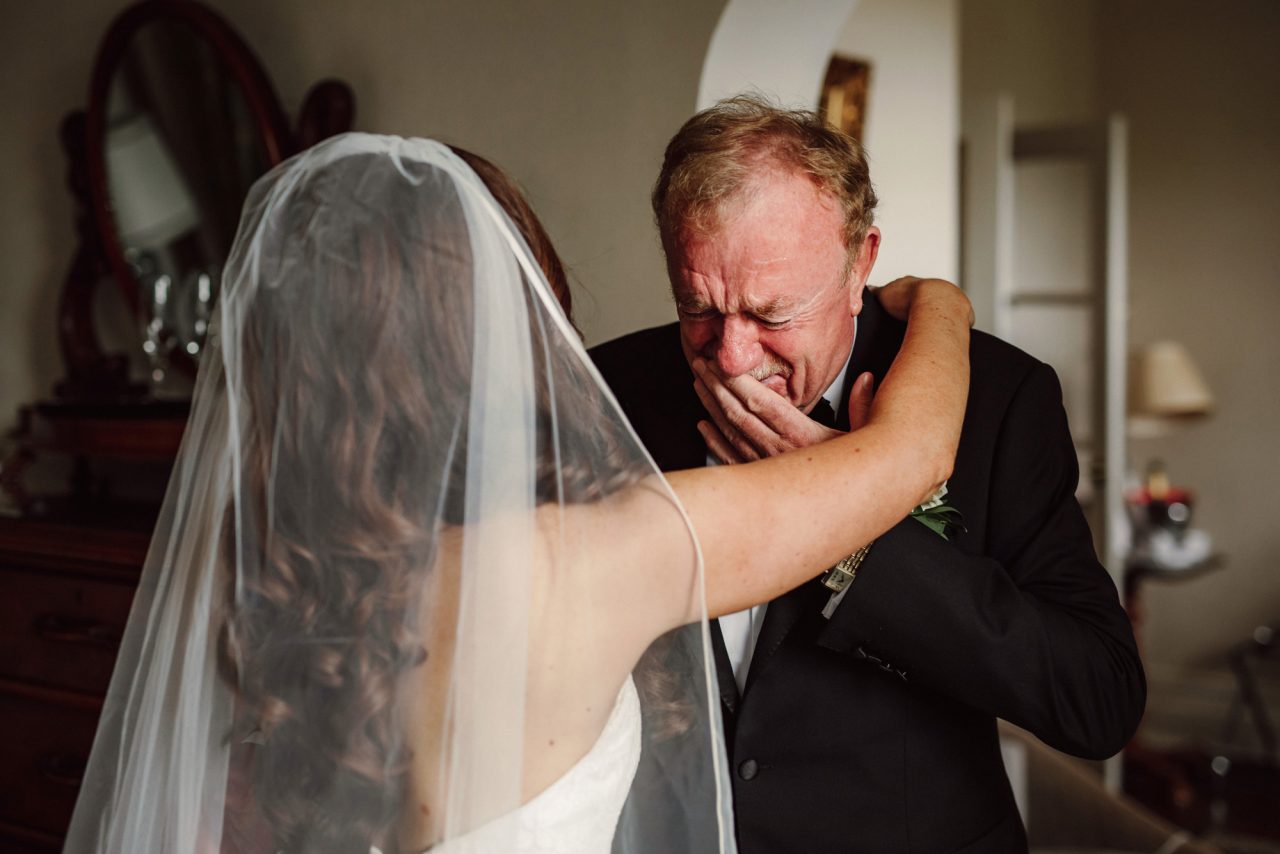 a bride embraces her crying father