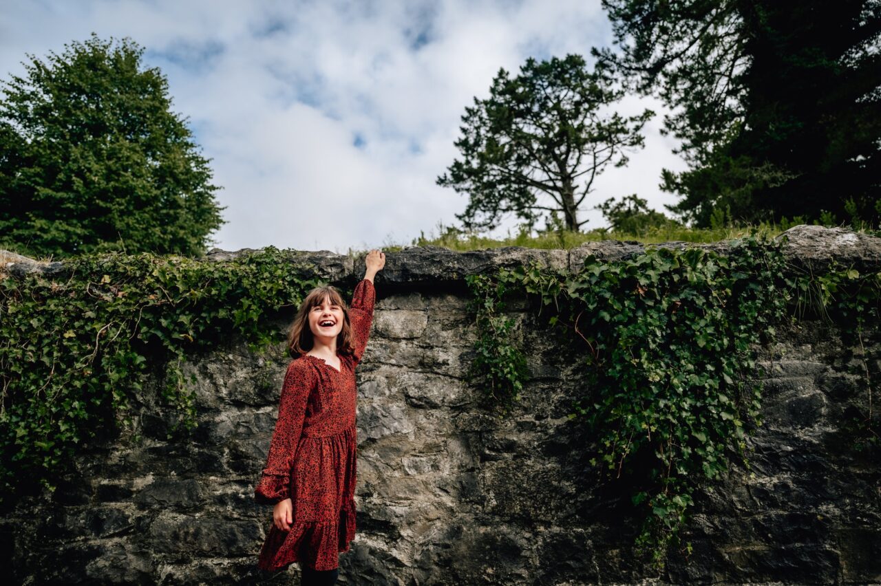 A young girl laughs in a photograph while being on vacation in Ireland