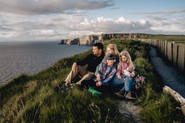 Family photographs on the West of Ireland. A family sitting admiring the Cliffs of Mother